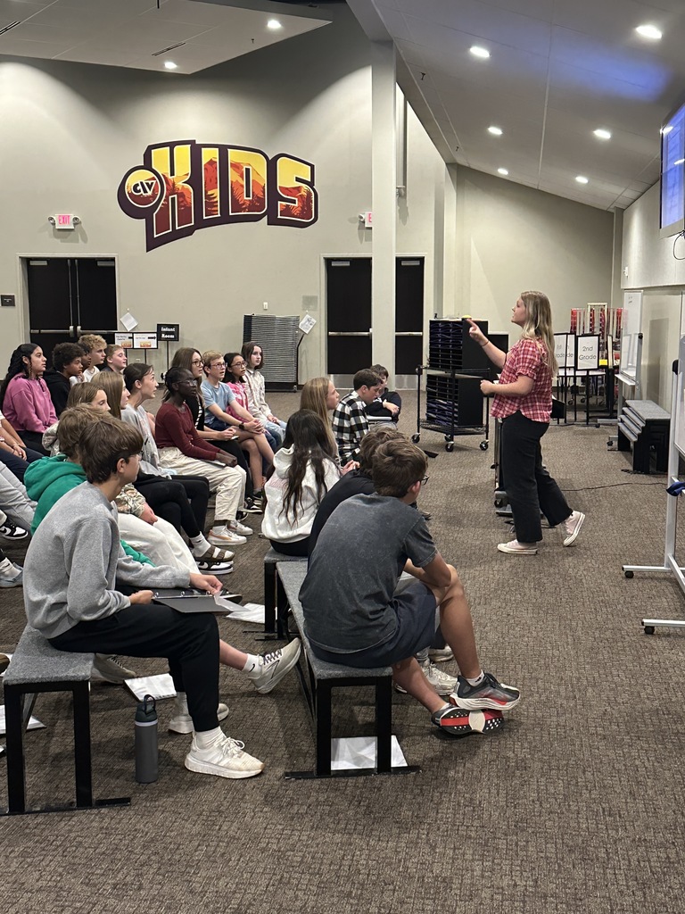 choir director leading her middle school students