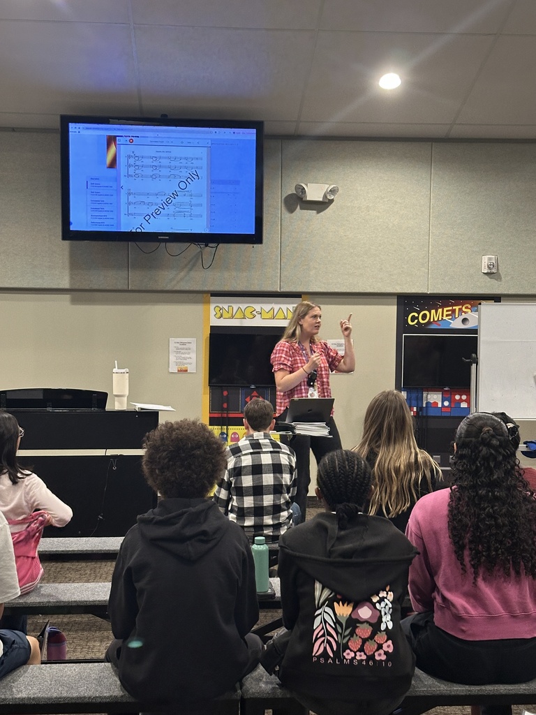 choir director leading her middle school students