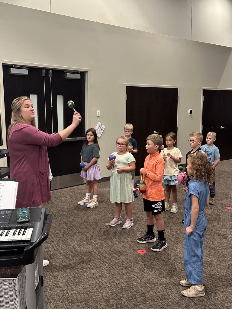 music teacher shaking maracas with 2nd grade students