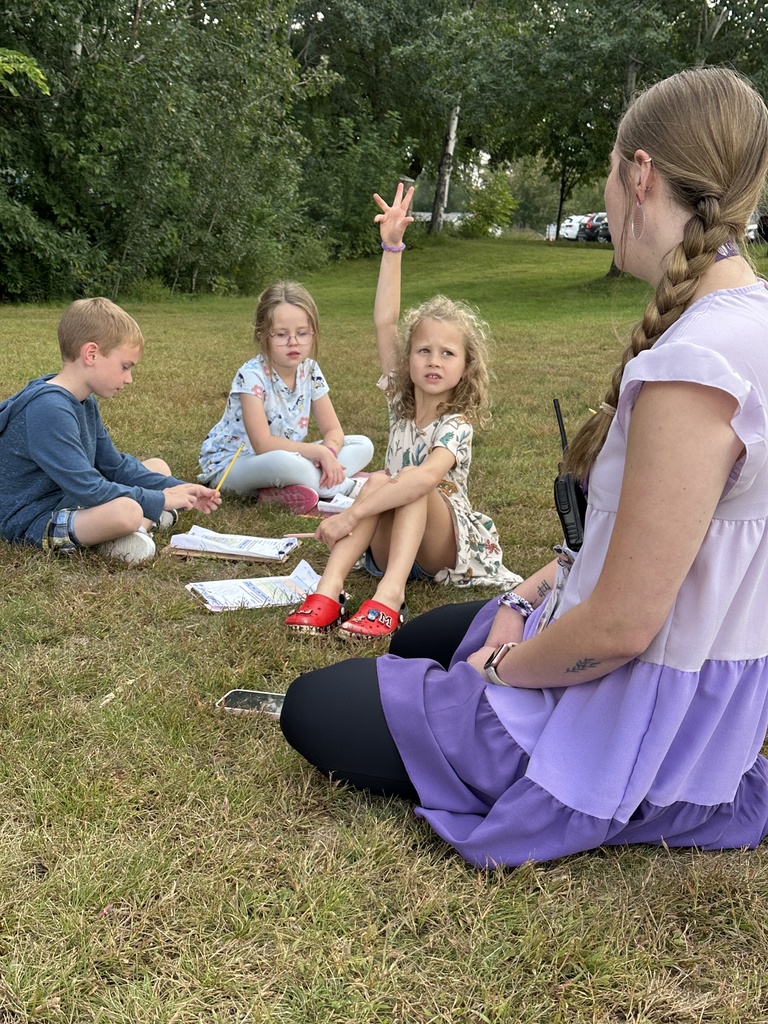 teacher sitting with her students outside as they observe the weather