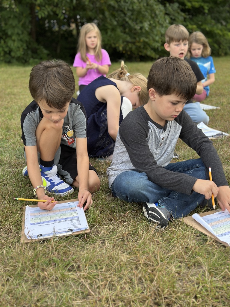 students writing observations on their clipboards