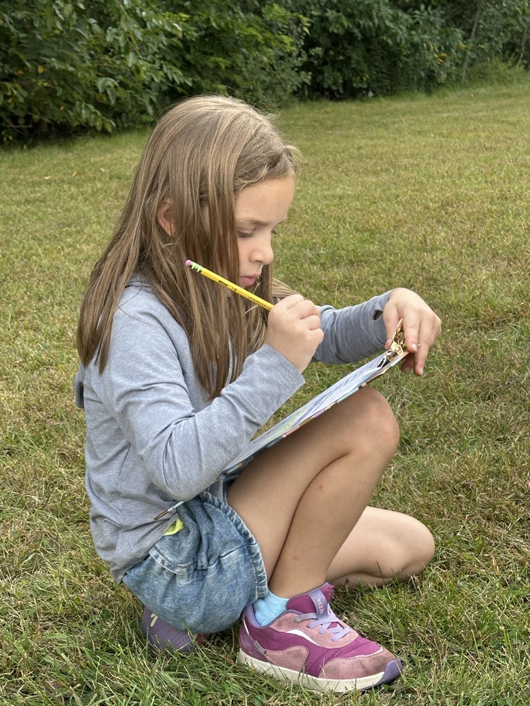 students writing observations on their clipboards