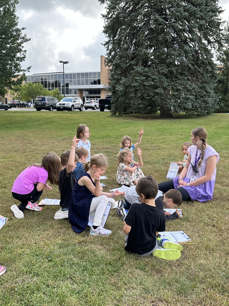 teacher sitting with her students outside as they observe the weather