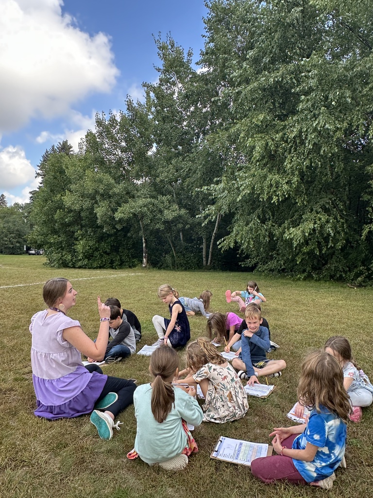 teacher sitting with her students outside as they observe the weather