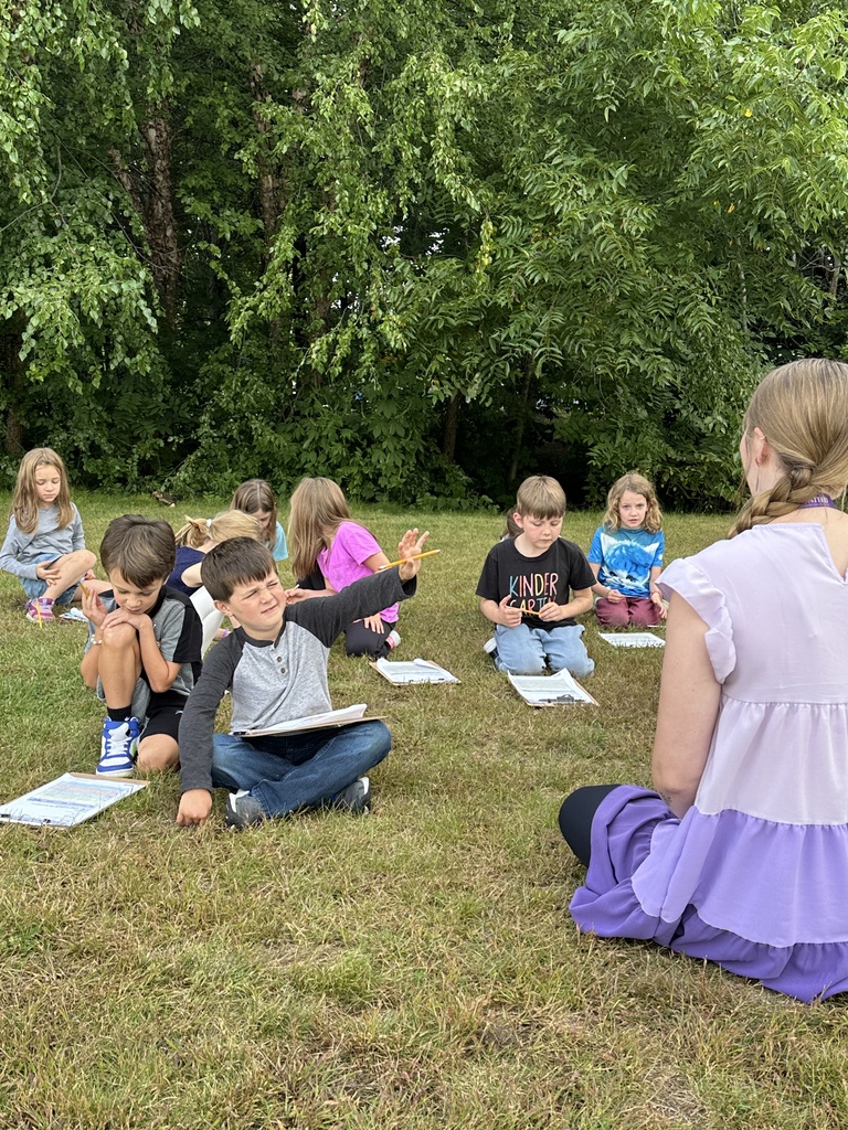 teacher sitting with her students outside as they observe the weather