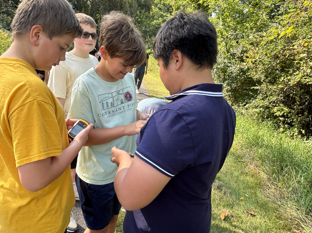 a group of 6th grade boys geocaching