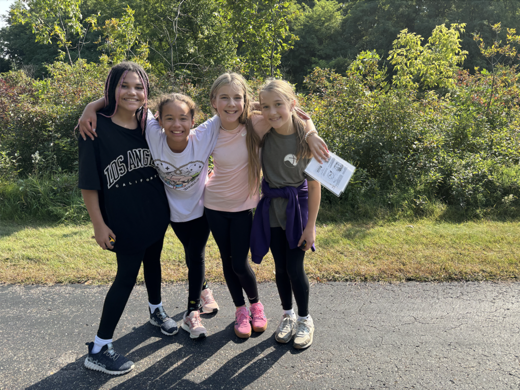 6th grade girls walking on a trail while geocaching