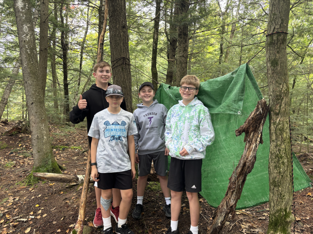 group of 7th and 8th grade boys putting up a tent