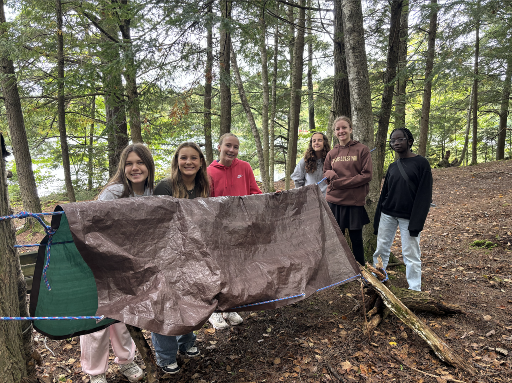 group of 7th and 8th grade girls putting up a tent