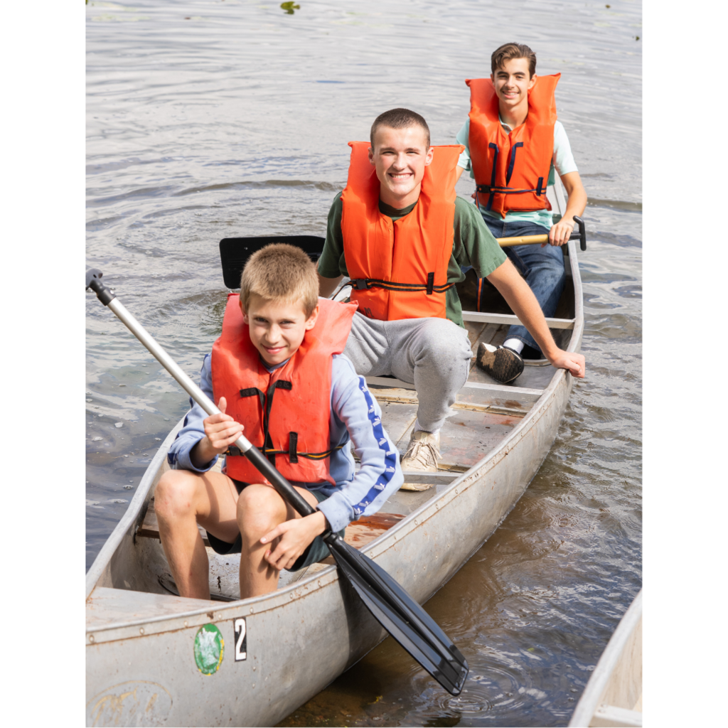 three high school boys in a canoe