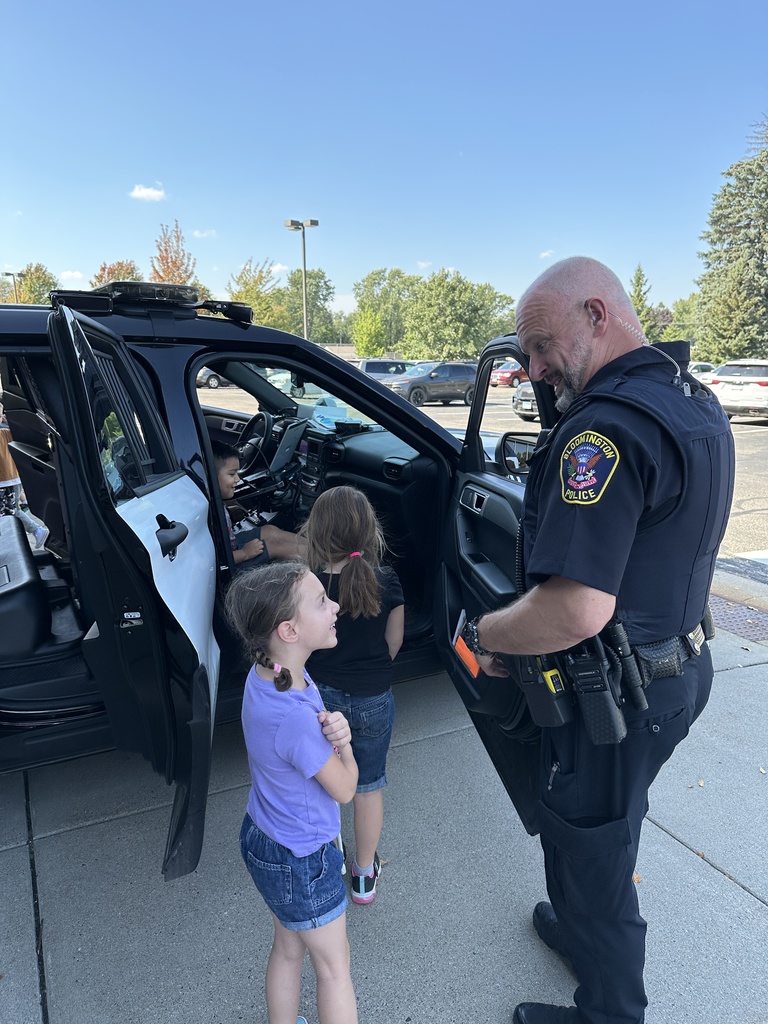 police officer talking to a girl next to a squad car