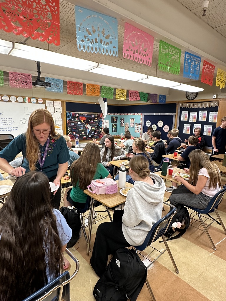 Spanish teacher and students eating ethnic food as a celebration