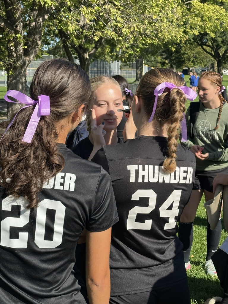 varsity girls soccer players applying face paint