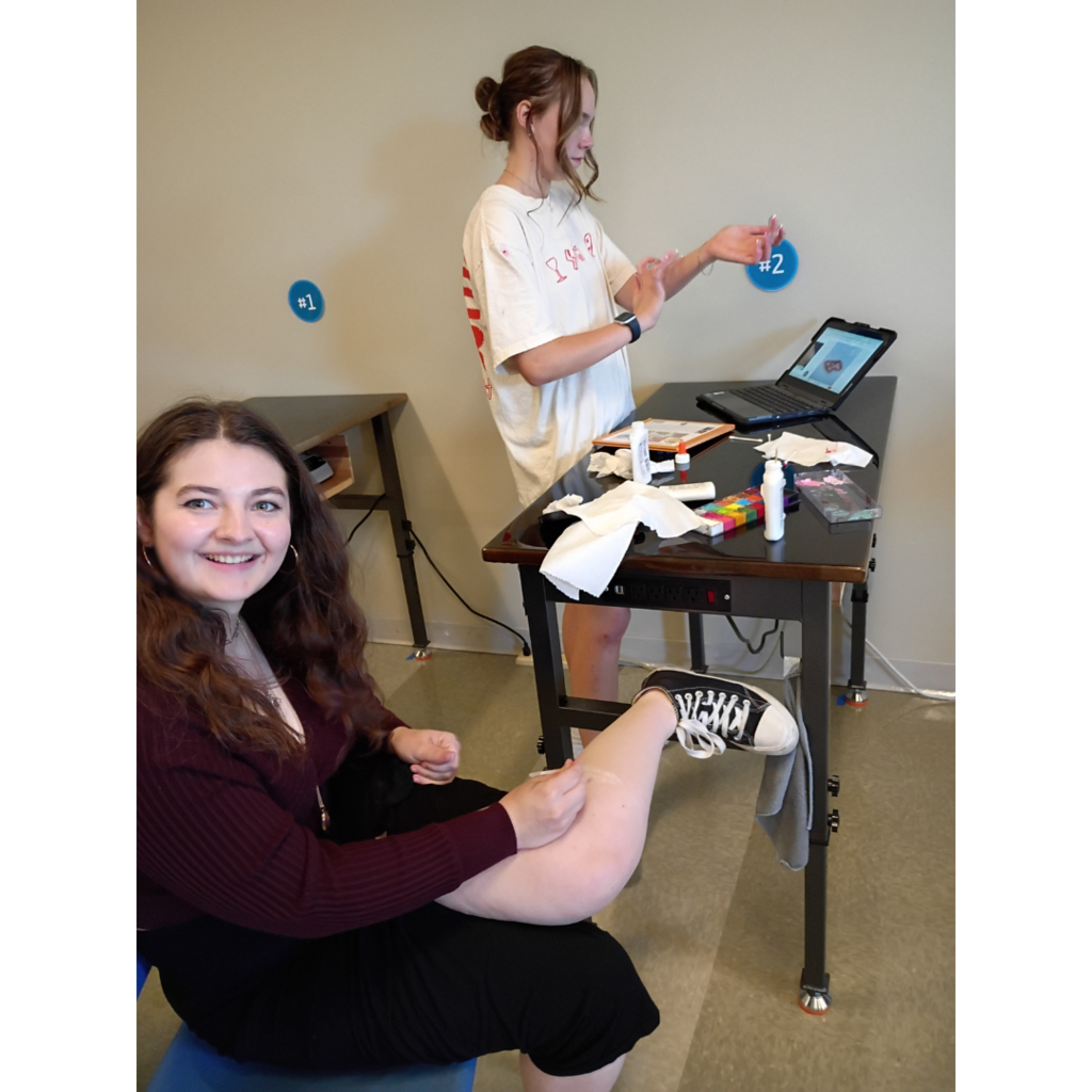 students applying make-up to look like and injury