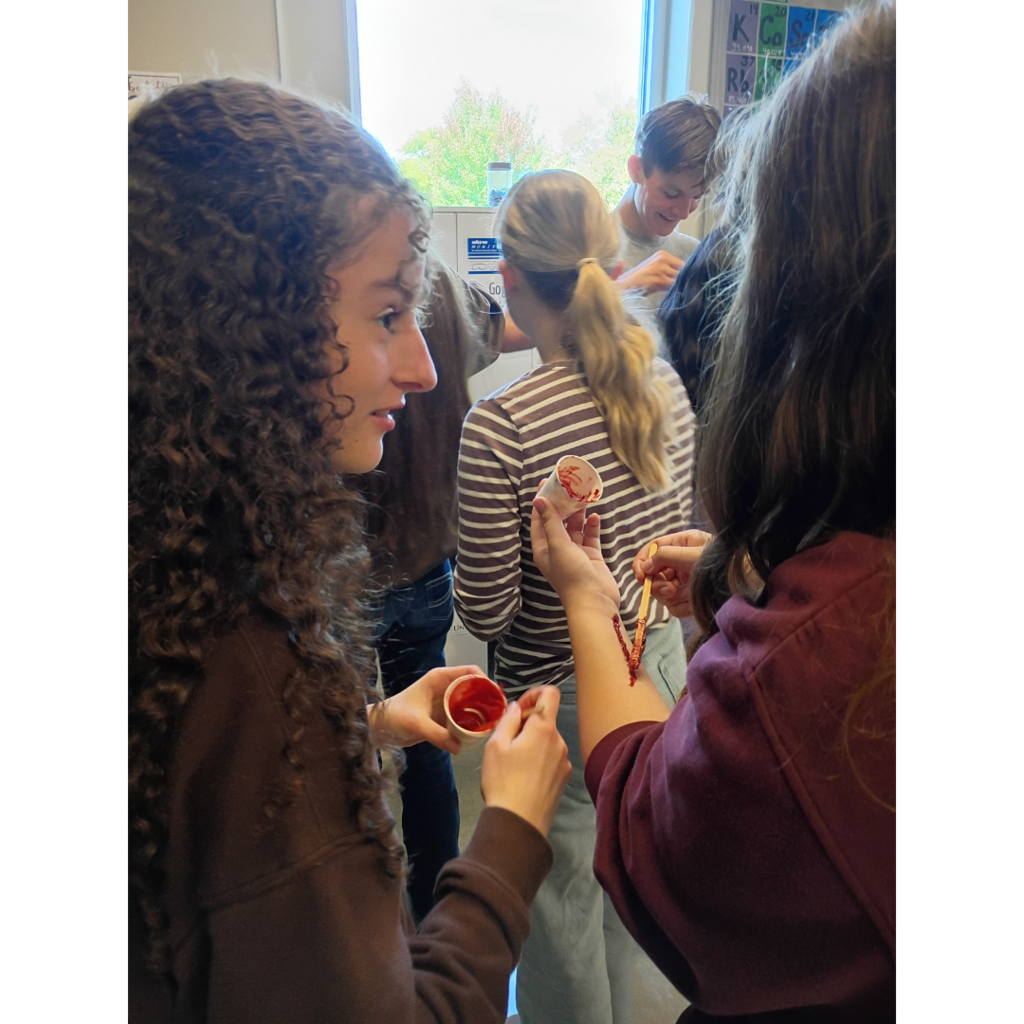 students applying make-up to look like and injury