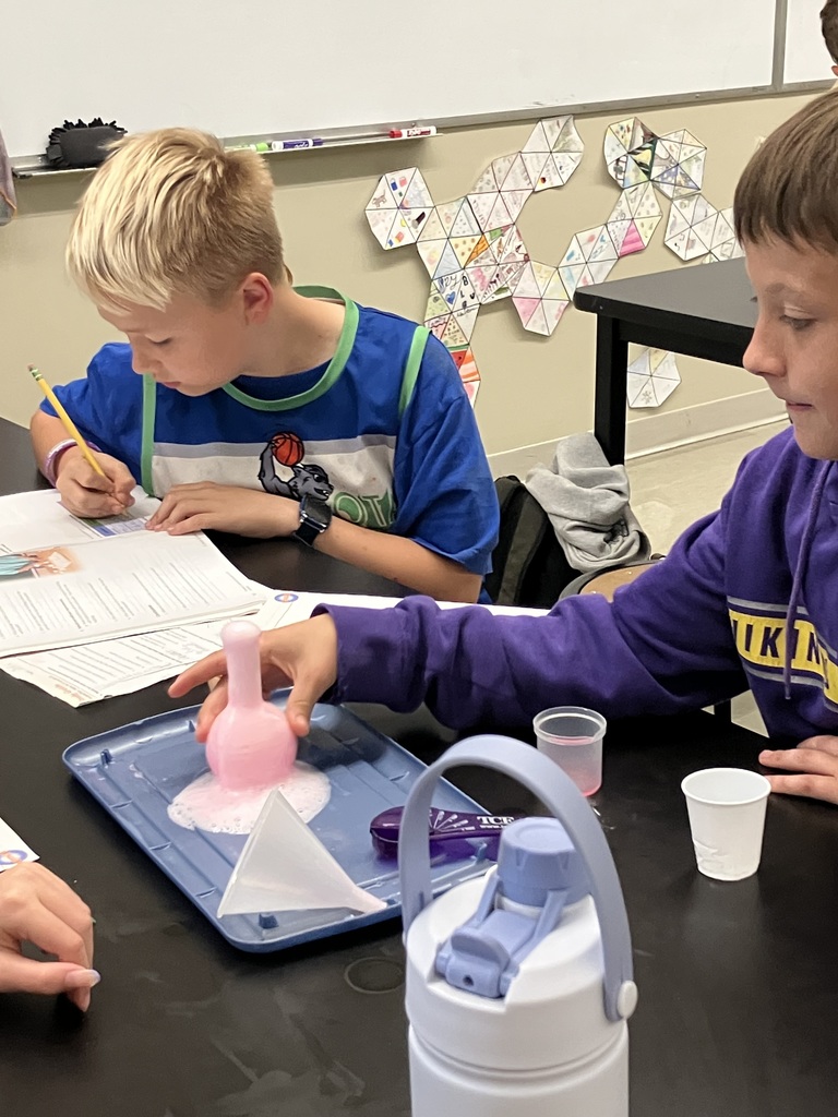 students doing a science experiment to mimic a volcanic eruption