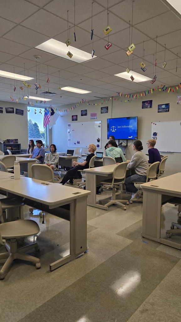 group of students listening to classmates up front talking