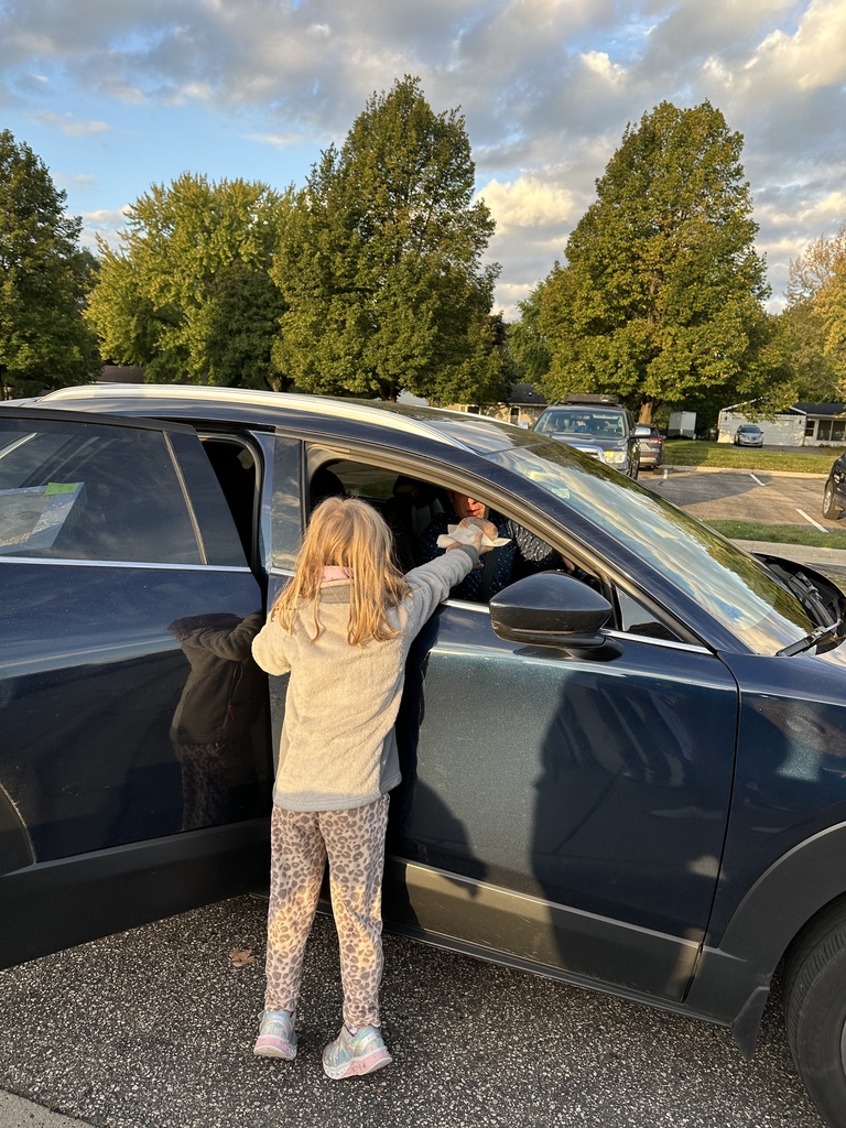 girl handing a donut through a car window