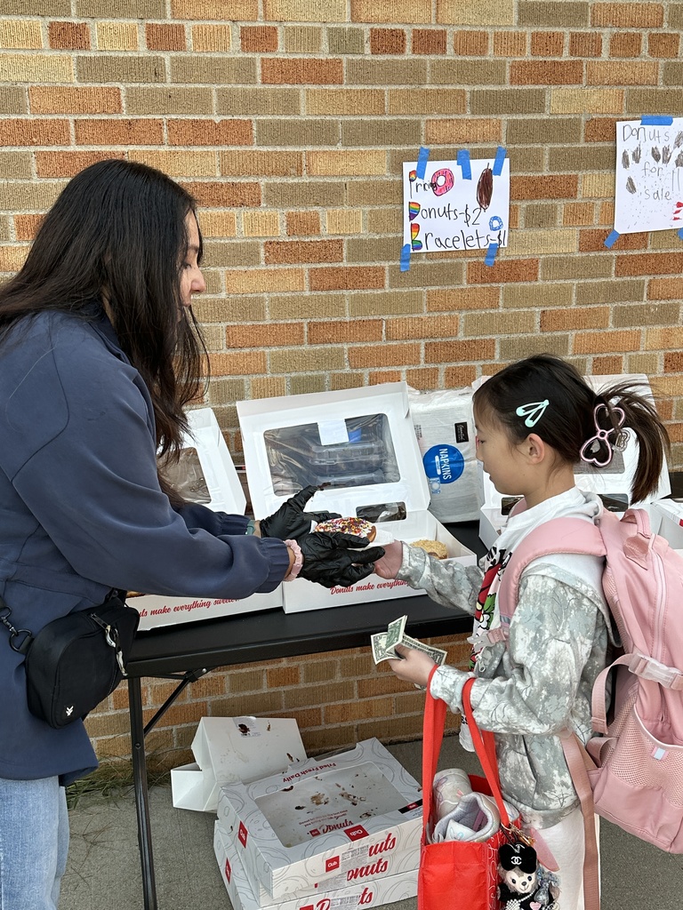 woman helping to hand out donuts to students