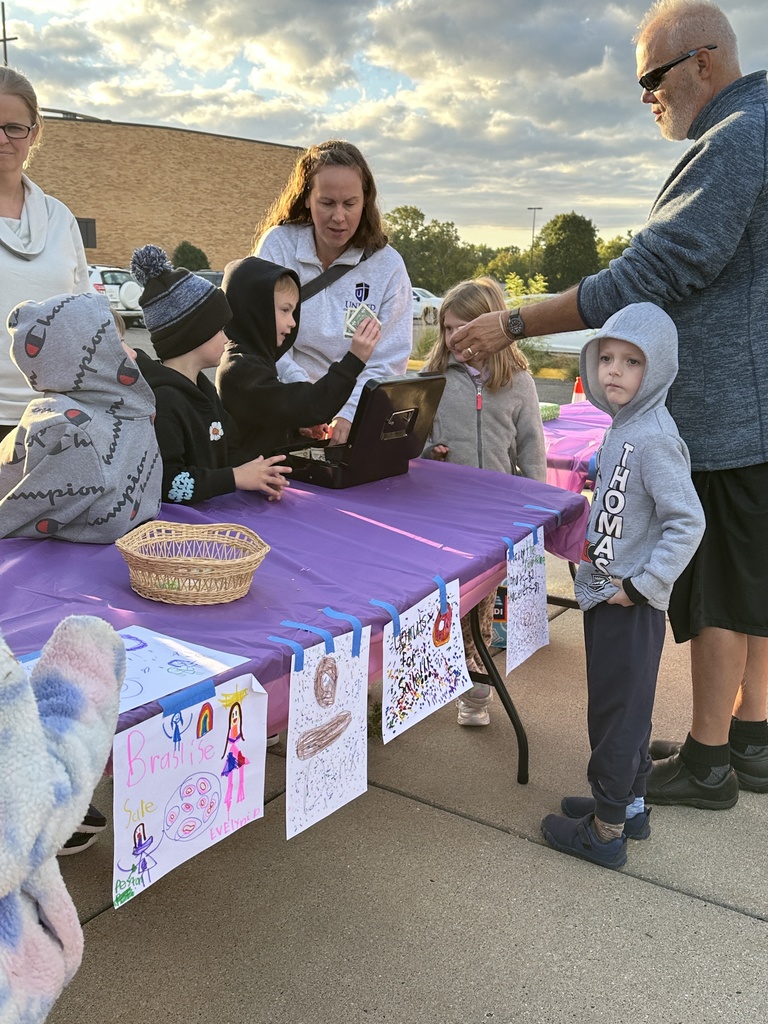 students taking money from parents as they sell donuts