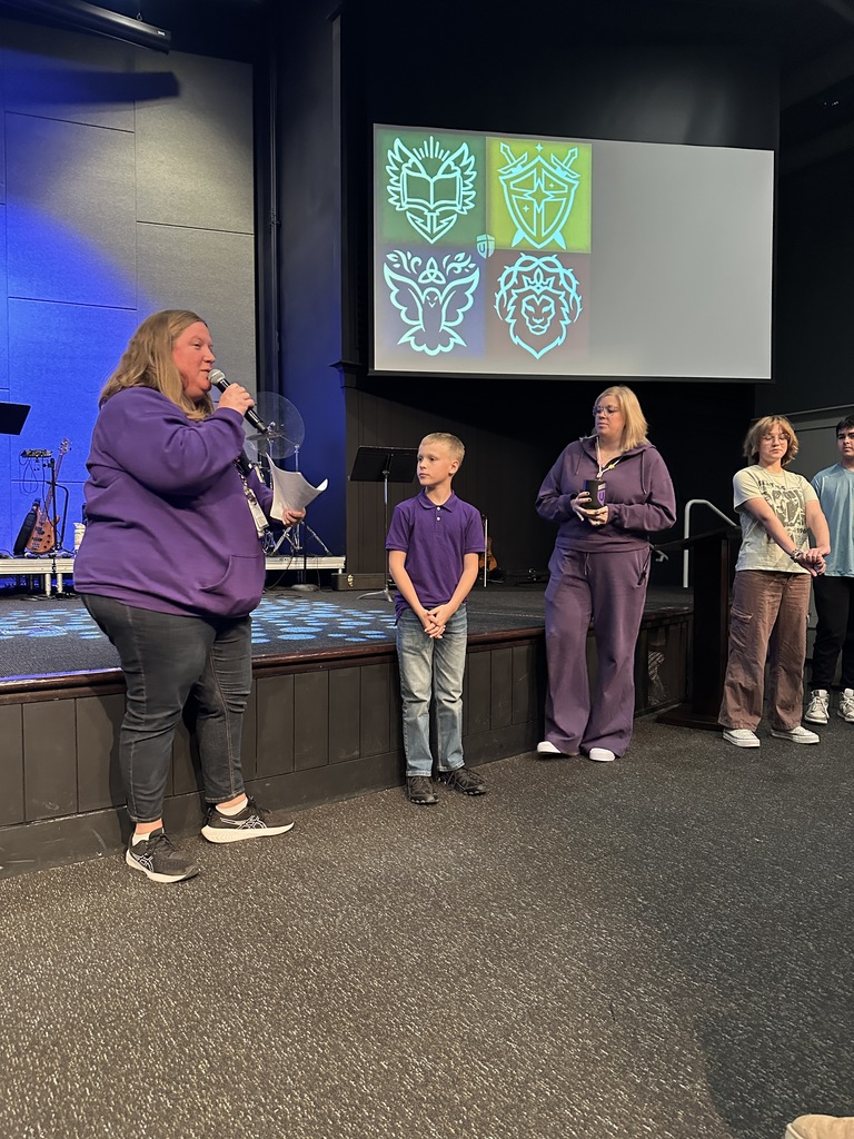 Middle school dean and a new student standing at the front during a chapel service