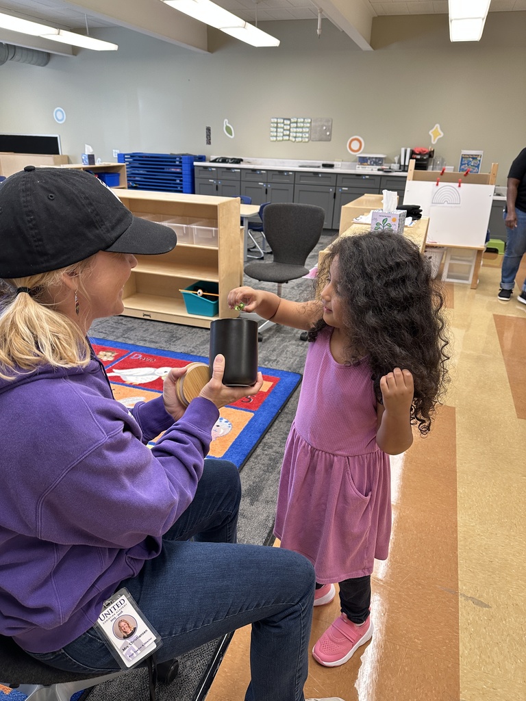 PreK student drawing something out of a jar