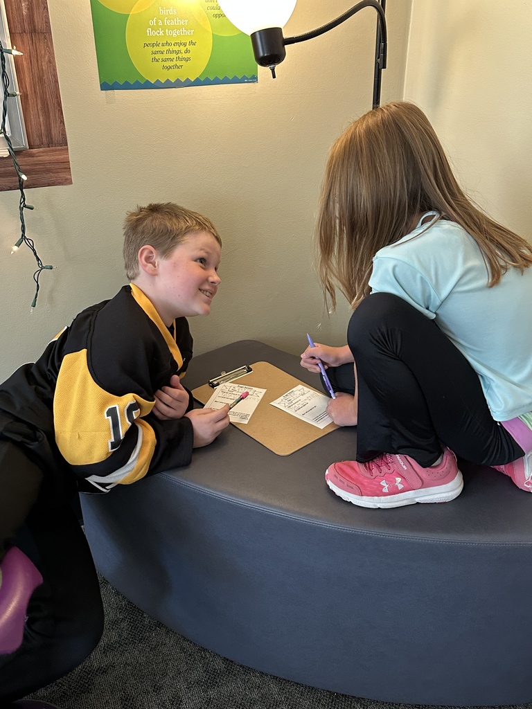 two students discussing what prayer requests they are writing down
