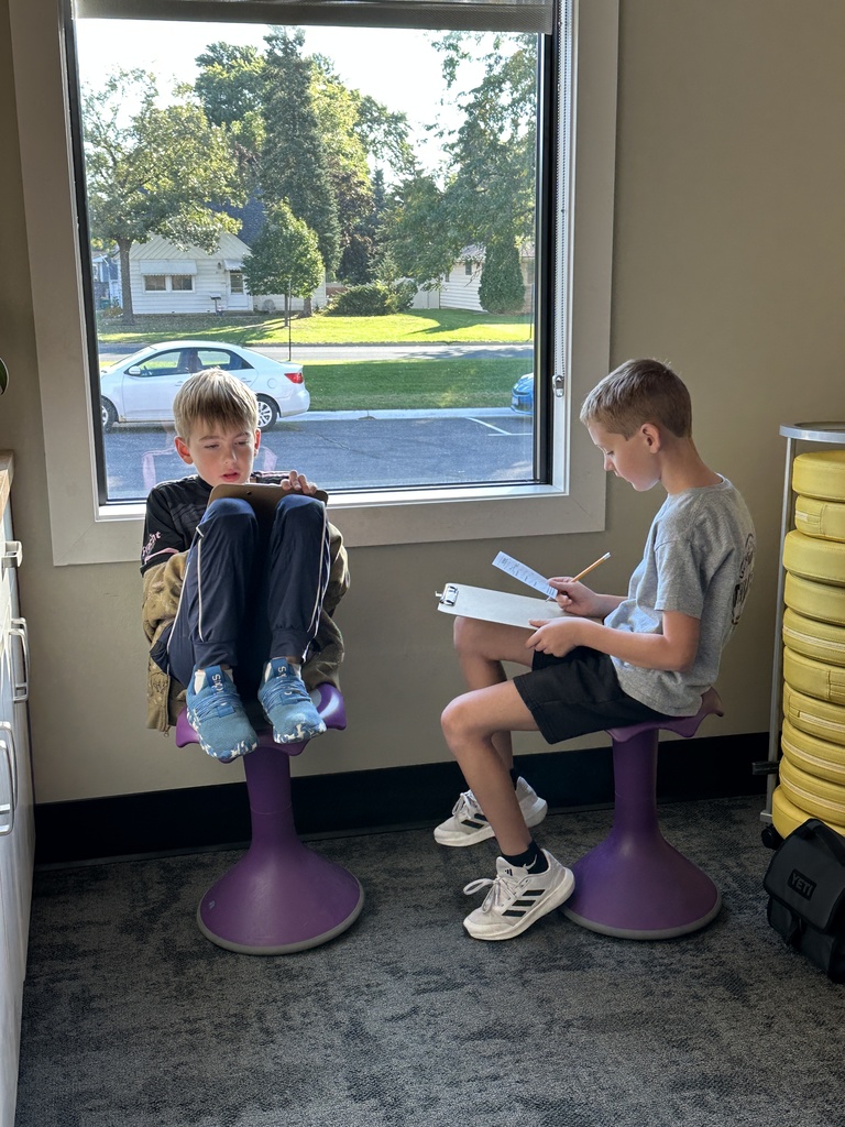 two students discussing what prayer requests they are writing down