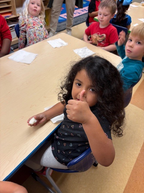 students giving thumbs up or down as their reaction to tasting an apple