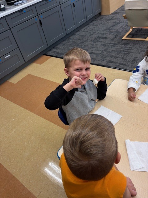 students giving thumbs up or down as their reaction to tasting an apple
