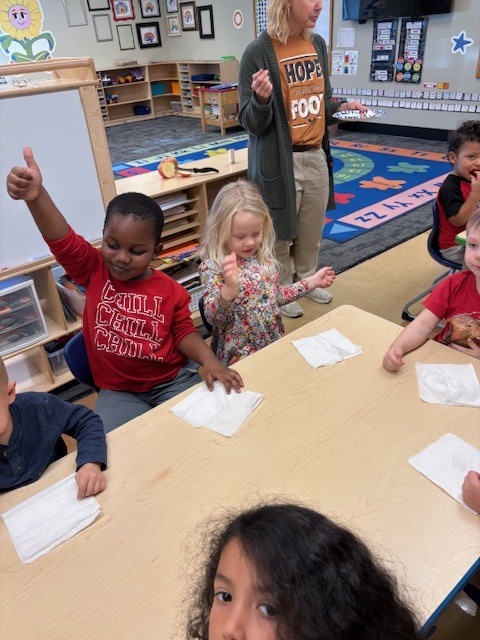 students giving thumbs up or down as their reaction to tasting an apple