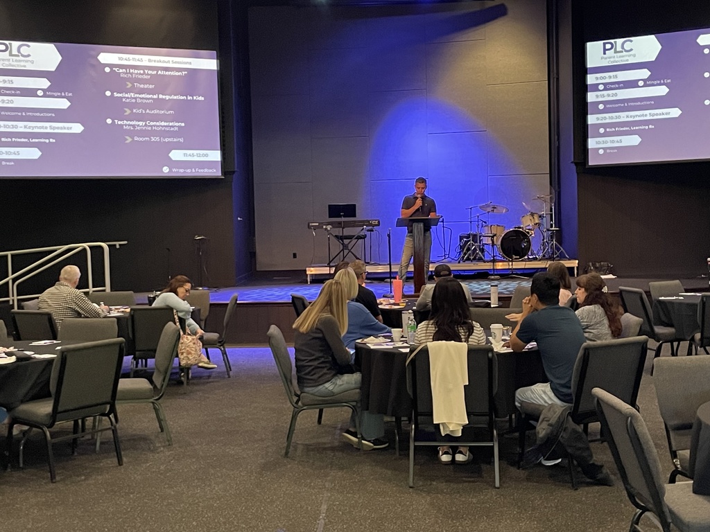 head of school speaking to a group of parents sitting at round tables
