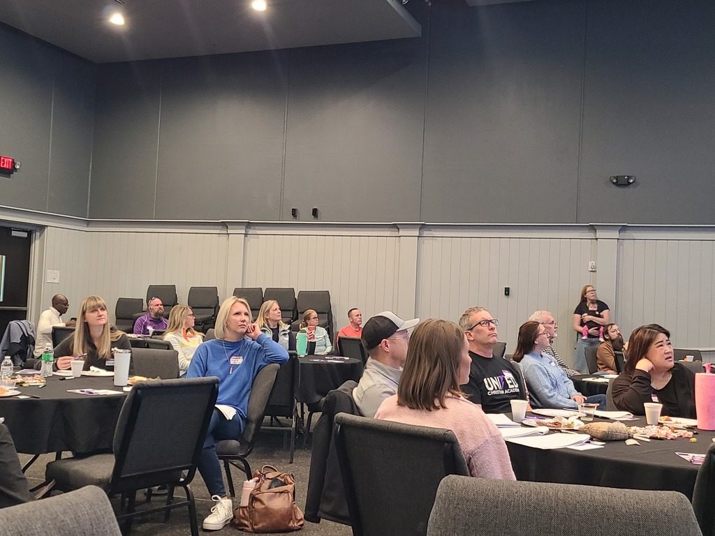 parents sitting at round tables listening to a presenter