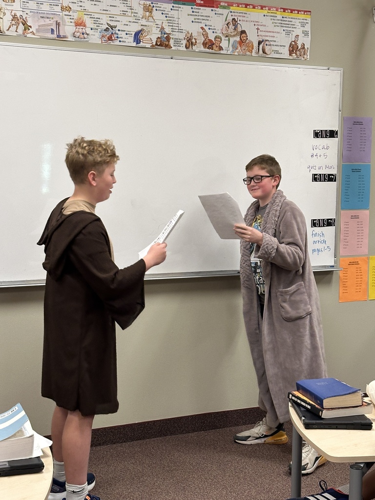 two students dressed up reading in front of the class