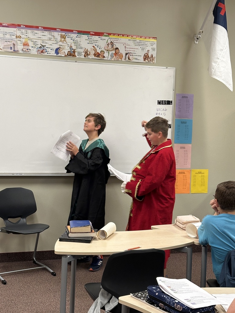 two students dressed up reading in front of the class