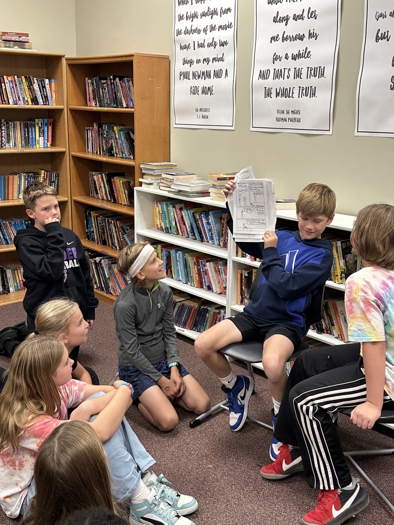two students reading their presentation to the class like a story book
