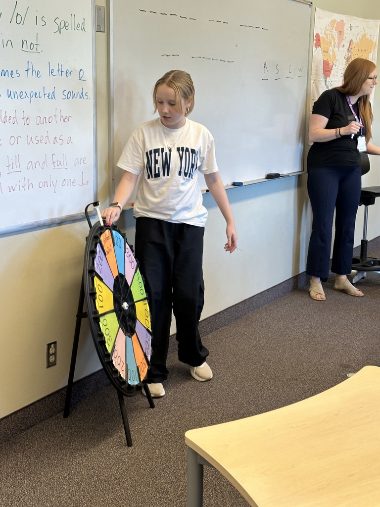 students spinning a wheel and guessing letters for a game in language arts class