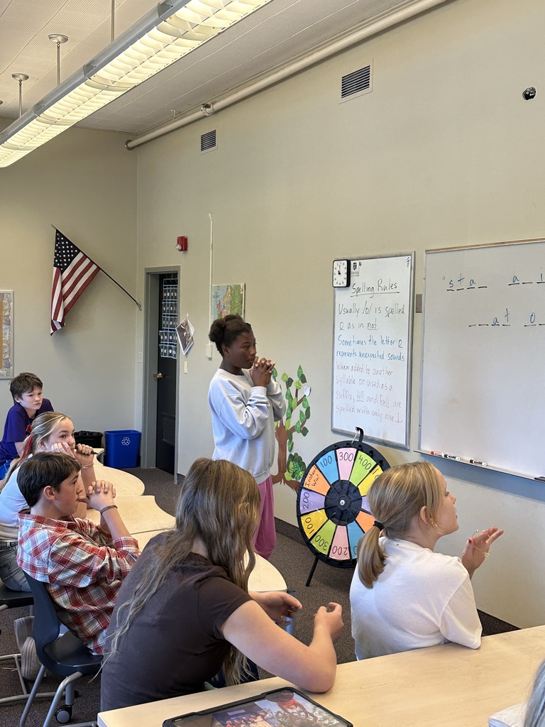 students spinning a wheel and guessing letters for a game in language arts class