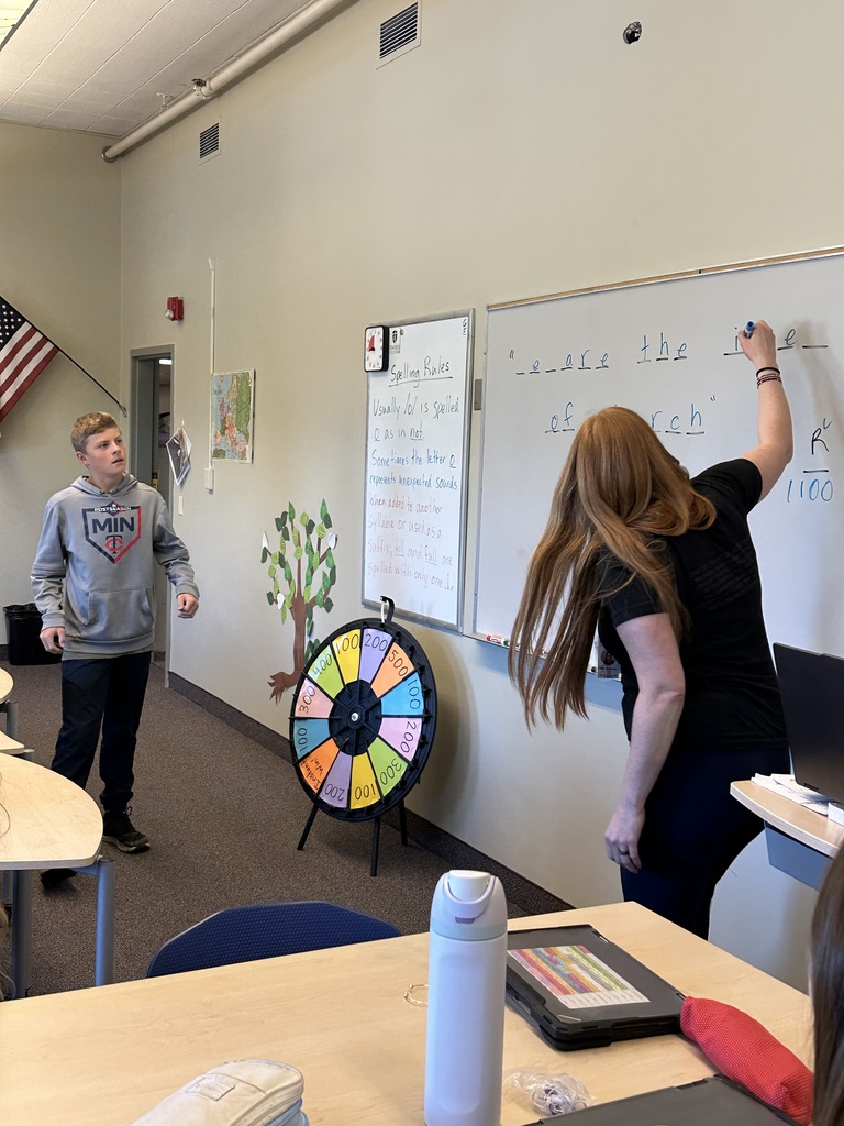 students spinning a wheel and guessing letters for a game in language arts class