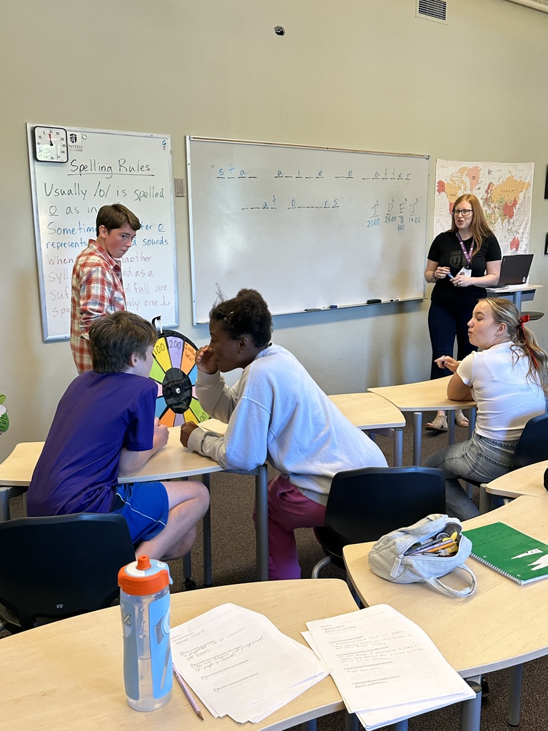 students spinning a wheel and guessing letters for a game in language arts class