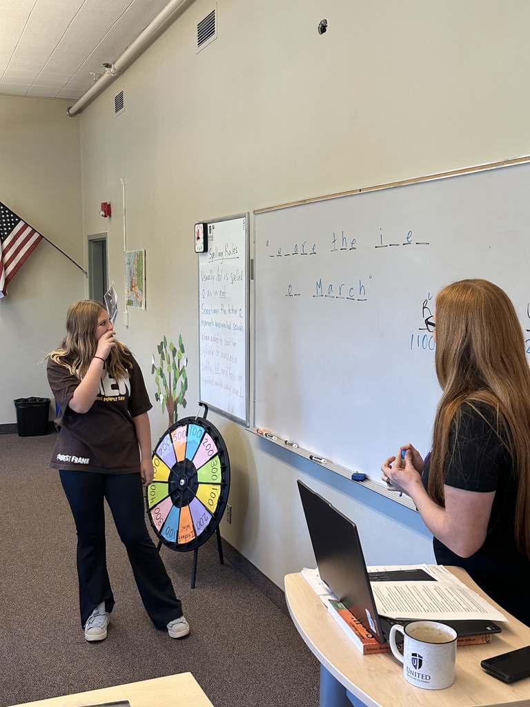 students spinning a wheel and guessing letters for a game in language arts class