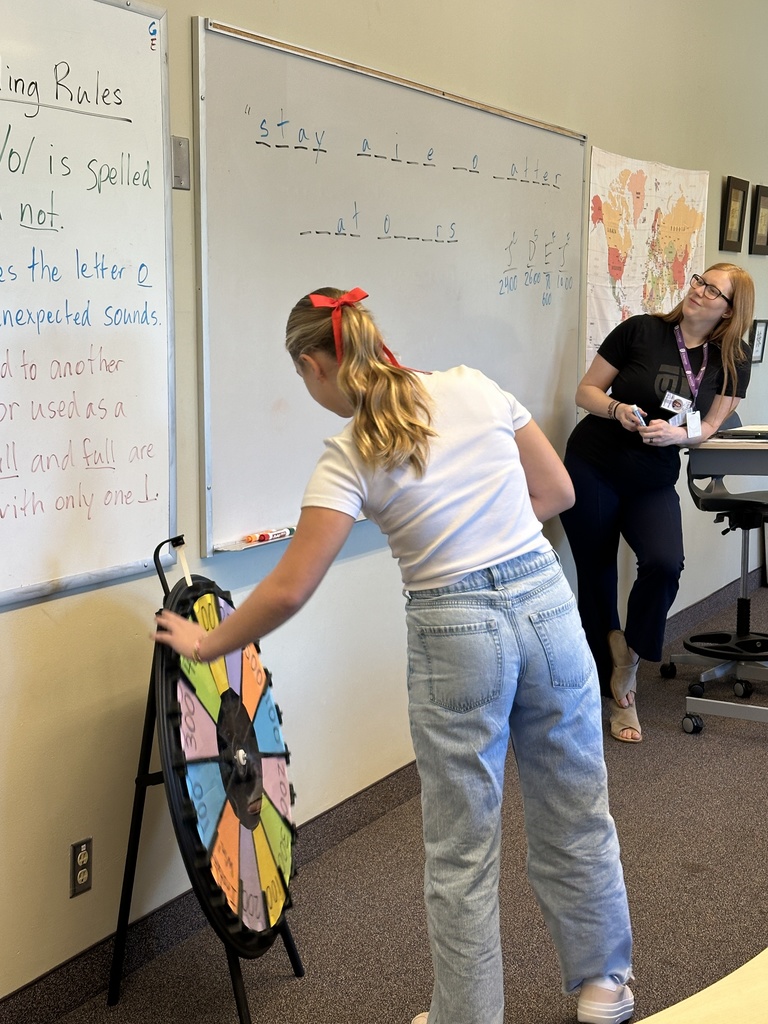 students spinning a wheel and guessing letters for a game in language arts class