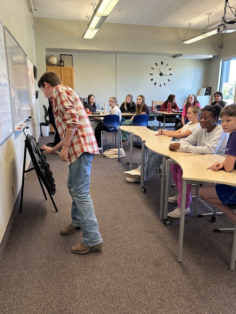 students spinning a wheel and guessing letters for a game in language arts class
