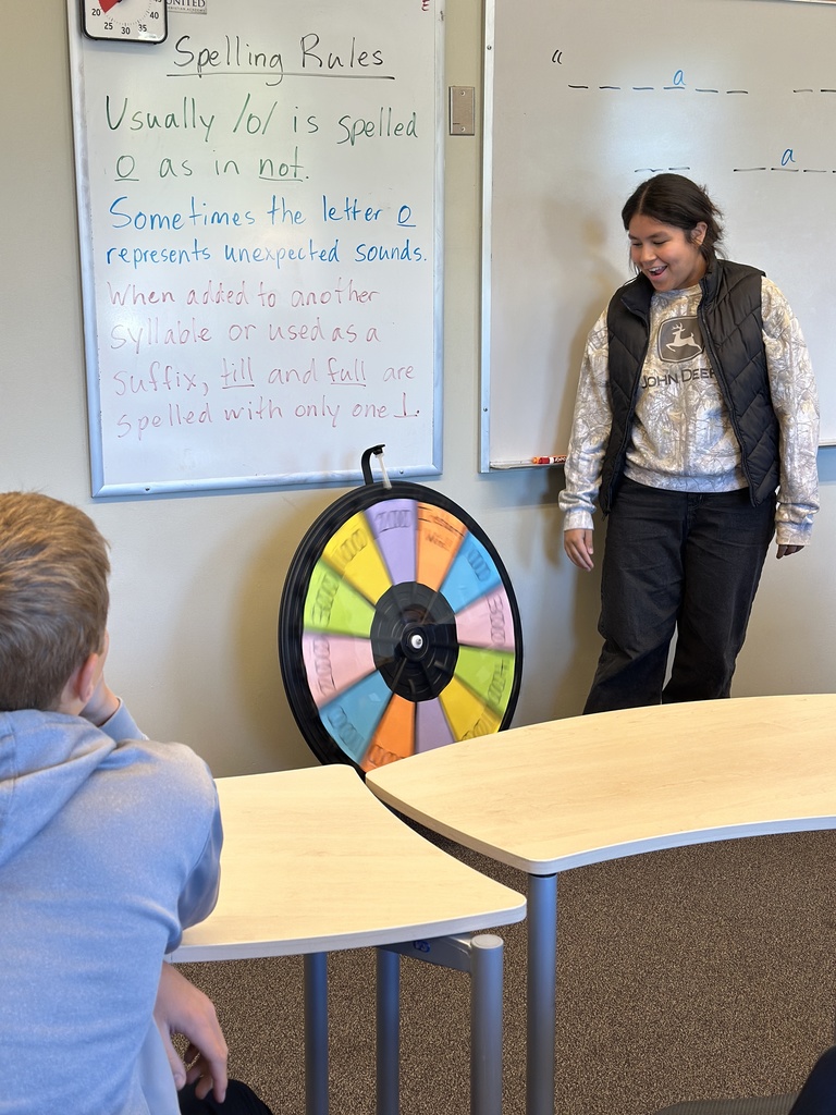 students spinning a wheel and guessing letters for a game in language arts class