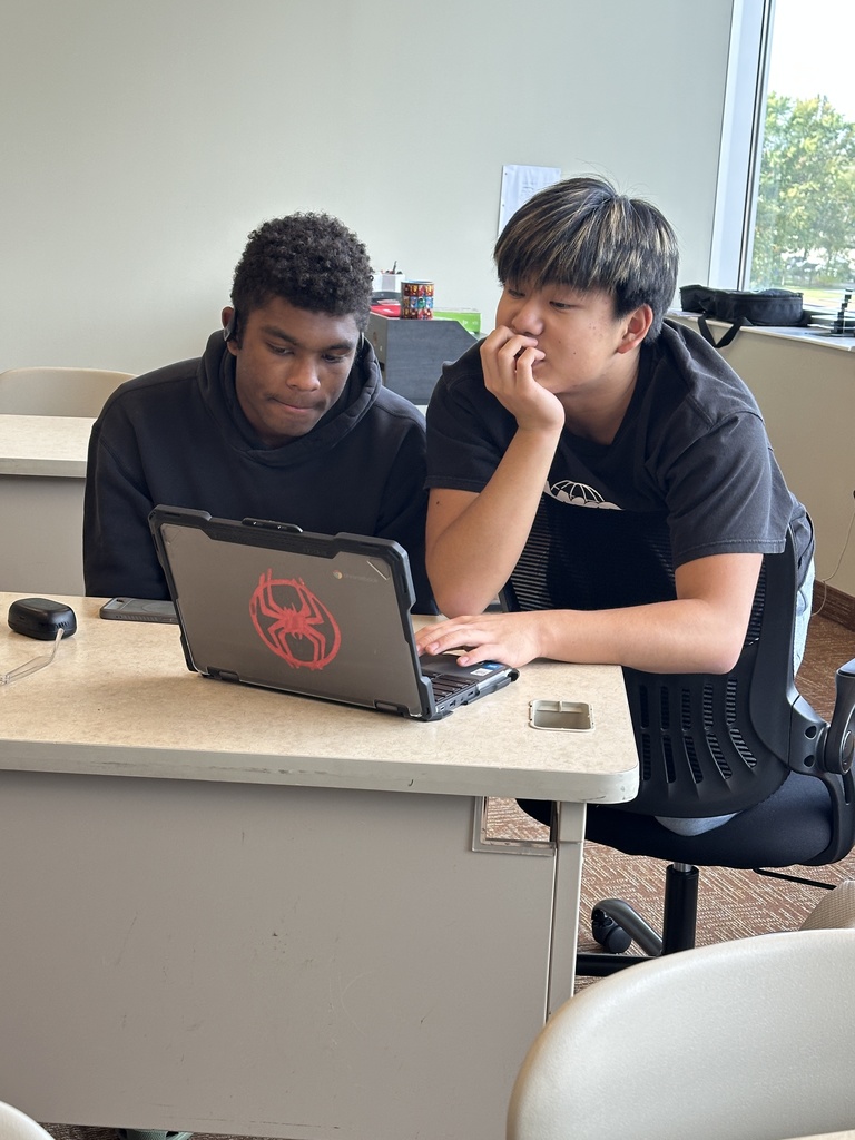 two high school boys working on a chromebook together