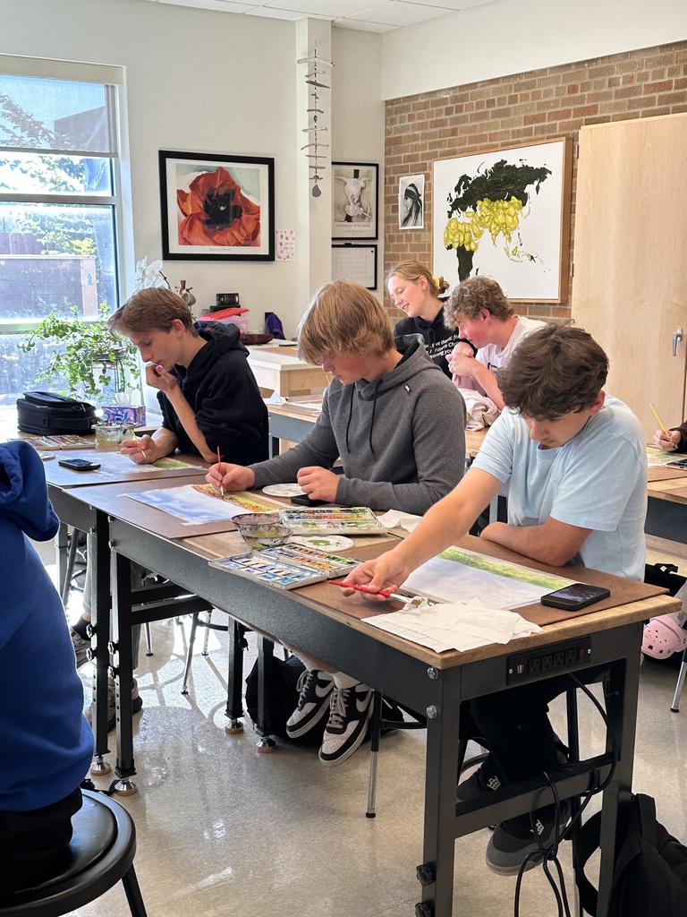 high school students doing a watercolor art project to paint fall leaves