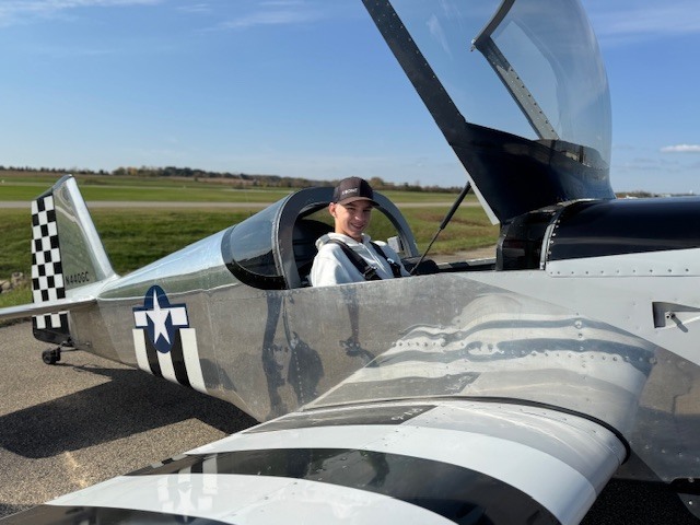 student sitting in a small airplane