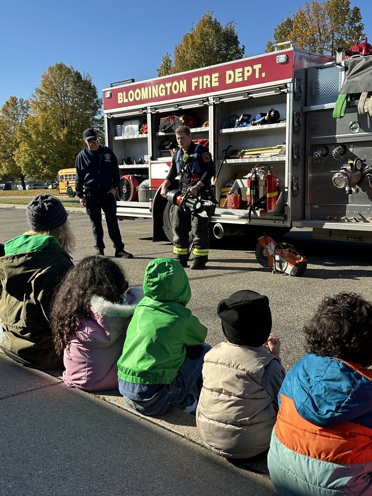 firefighters showing preK students equipment from their truck