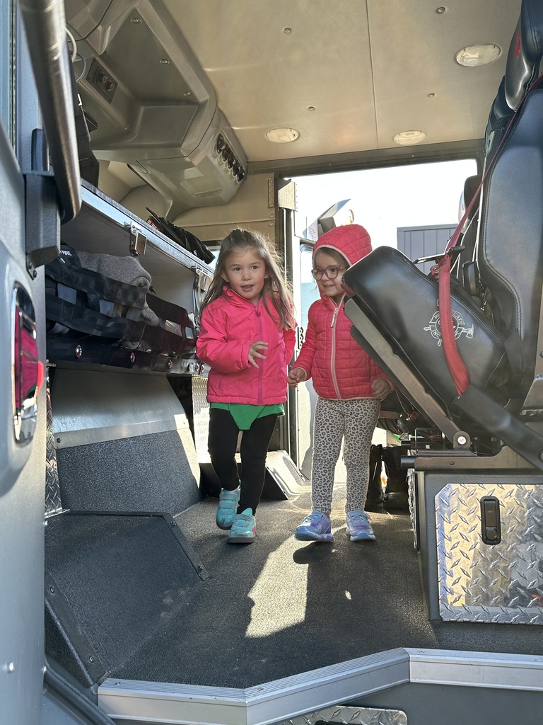 two students climbing inside a firetruck