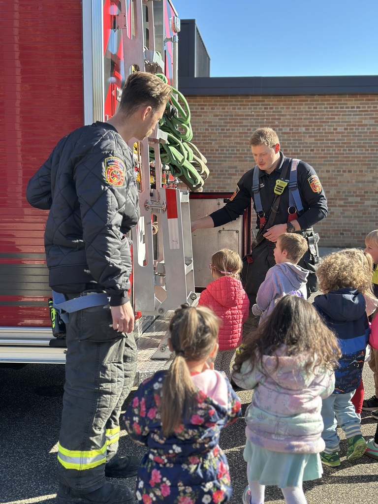 firefighters showing preK students equipment from their truck